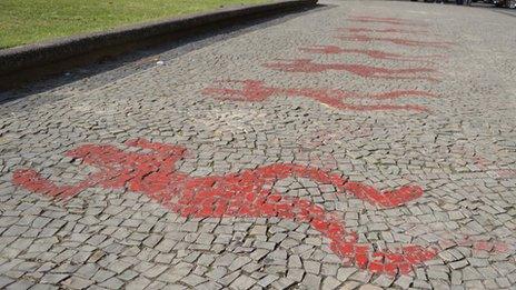 Figures in red paint on the pavement in front of the Candelaria