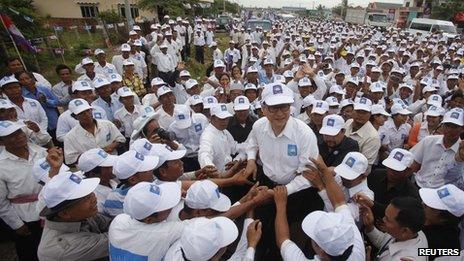 Sam Rainsy (centre), president of the Cambodia National Rescue Party, is surrounded by his supporters in Kampong Speu province 20 July 2013