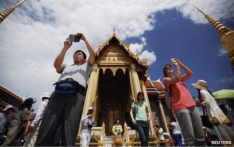 Tourists take photos at the Grand Palace in Bangkok