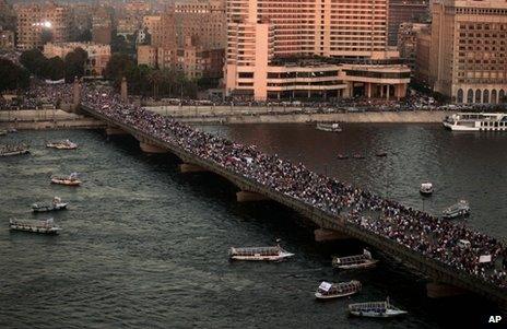 Anti-Morsi demonstrators cross a bridge in Cairo, 26 July
