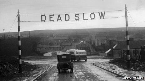 A "dead slow" sign on a road c. 1930