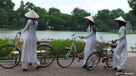 Women in traditional ao dai dress and conical hats