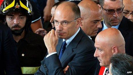 taly"s Prime Minister Enrico Letta (C) looks on during a mass funeral on July 30, 2013, in Monteruscello, southern Italy