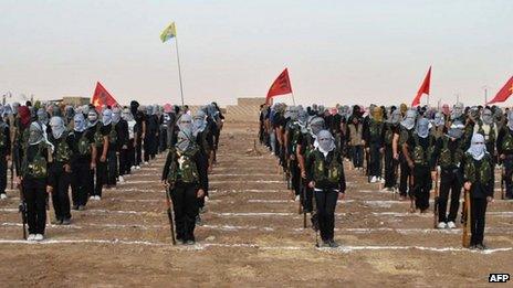 Kurdish opposition fighters attend a ceremony on 18 July 2013, in the northern Syrian border village of Qamishli