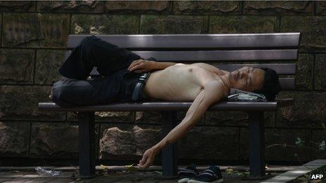 A man takes a rest in a park from the heat in Shanghai, 2 July 2013