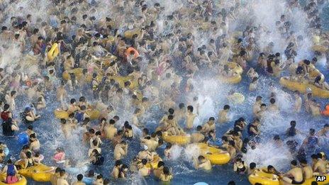Visitors at a water park enjoy themselves in Wuhan in central China's Hubei province, 13 July 2013