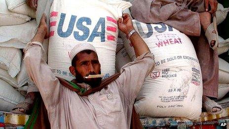 A man unloads wheat at a refugee camp in Pakistan