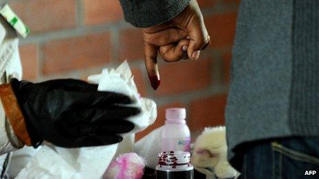A Zimbabwean voter dips their finger into ink after voting