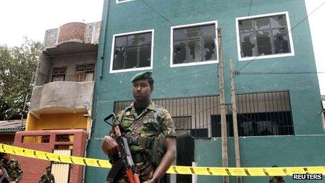 Special Task Force commandos stand guard outside a vandalised mosque in Colombo on 11 August 2013