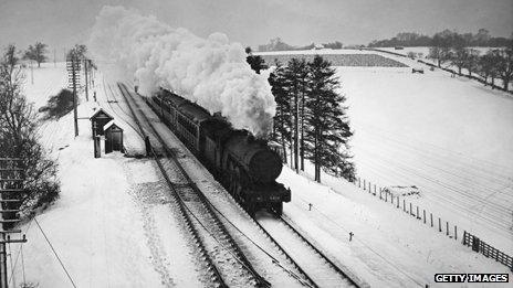 An old steam train passes over the Welwyn viaduct in snowy conditions in 1938