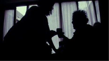 Nurse caring for patient in silhouette