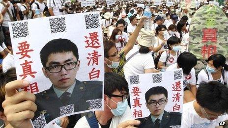 In this image taken on 20 July 2013, in Taipei, Taiwan, protesters hold posters that read "Give the truth" next to portraits of Taiwan soldier Hung Chung-chiu, who died in early July after being forced to perform a vigorous regime of calisthenics in sweltering heat on a base in suburban Taipei