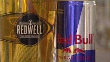 Pint of Redwell beer and can of Red Bull energy drink