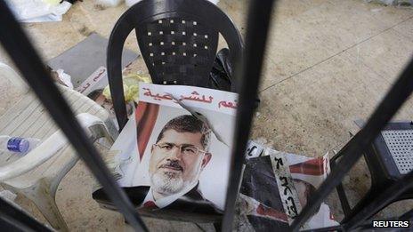 A poster of deposed Egyptian President Mohamed Morse is seen outside a burnt mosque in Cairo 16 August 2013