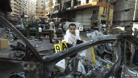 A forensic inspector examines a burnt vehicle at the site of a car bomb that occurred on Thursday in Beirut's southern suburbs, 16 August, 2013.