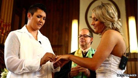 Natasha Vitali (L) and Melissa Ray (R) exchange rings with marriage celebrant Rev Matt Tittle at the Auckland Unitary Church on August 19, 2013 in Auckland, New Zealand