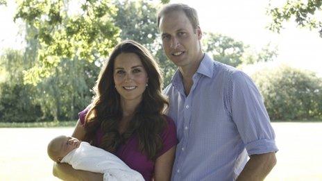 The Duke and Duchess of Cambridge sitting in a garden with their baby, Prince George