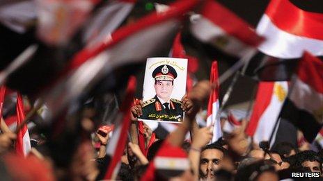 Protesters opposed to President Mohammed Mursi hold a poster featuring the head of Egypt's armed forces General Abdel Fattah al-Sisi in Tahrir Square in Cairo (3 July 2013)