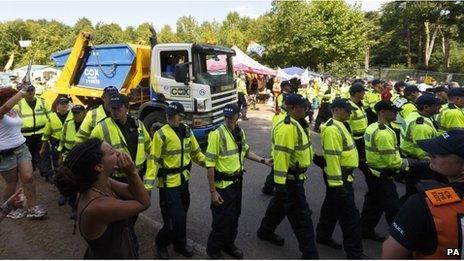 Police escort a lorry arriving at the site