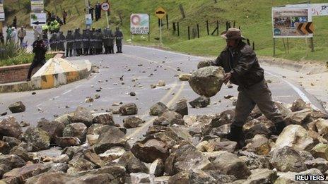 A protester drops a stone on a road in La Calera, near the capital Bogota on 23 August 2013