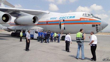 A handout picture released by the official Syrian Arab News Agency (SANA) on August 27, 2013, allegedly shows people gathering near a Russian aircraft loaded with humanitarian aid, food and medical supplies after its arrival at Latakia airport in Syria.