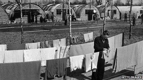 A German POW hangs out washing at the camp in 1947