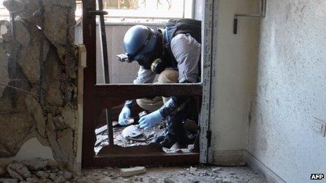 A United Nations (UN) arms expert collects samples as they inspect the site where rockets had fallen in Damascus eastern Ghouta during an investigation into a suspected chemical weapons strike near the capital taken on 29 August 2013.