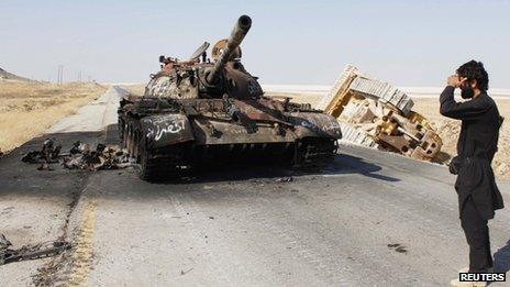 free syrian army fighter and burnt out tank