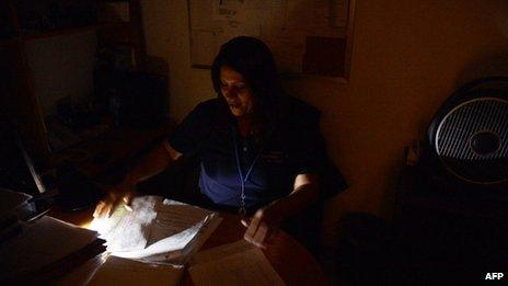 A woman works during a blackout in Caracas on 3 September, 2013.