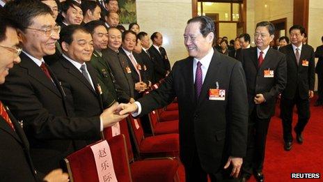 Chinese former Politburo Standing Committee member, Zhou Yongkang, centre, shakes hands with delegates at the National People's Congress at the Great Hall of the People in Beijing, in this picture taken 12 March 2011