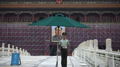 A paramilitary policeman guards his post in front of Tiananmen Gate, surrounded by scaffolding for repainting work ahead of the 1 October National Day in Beijing, 28 August 2013