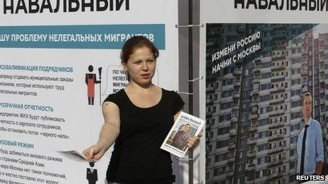 A campaign staffer of opposition leader Alexei Navalny distributes leaflets near a campaign booth on a street in Moscow on 3 September 2013
