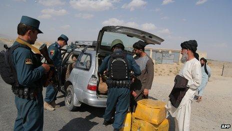 Afghan policemen search passengers at a checkpoint where Taliban militants kidnapped Fariba Ahmadi Kakar in Ghazni province on 14 on August 2013