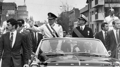 Gen Augusto Pinochet (left) waves from the motorcade in Santiago, shortly after his coup that killed President Allende on 11 September 1973.