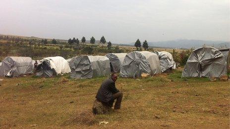 Man in front of tents in Kenyan refugee camp