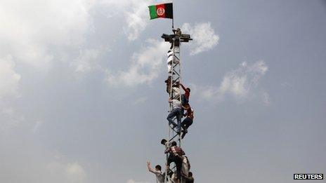 Afghan football fans climb an electrical pole to celebrate winning the South Asian Football Federation championship after their team defeated India during the final match, in Kabul on 12 September 2013.