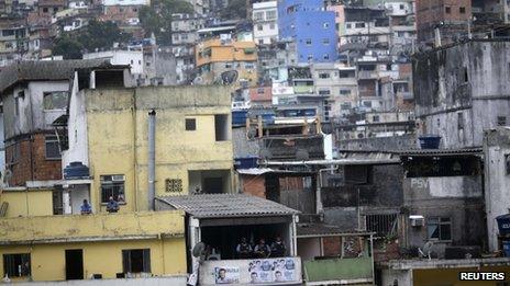 Police officers can be seen on the balcony of a house in Roncinha on 20 September, 2012