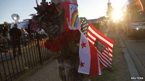 Flowers, flags and a child's drawing are pictured at a makeshift memorial outside the Navy Yard two days after a gunman killed 12 people before police shot him dead, in Washington, 18 September 2013