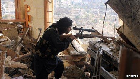 A Free Syrian Army fighter aims his weapon during a clash with government forces in Idlib, northwestern Syria.