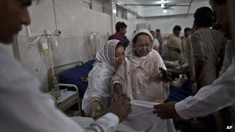 A Pakistani woman grieves as doctors cover the body of her mother, killed in a suicide attack on a church in Peshawar, Pakistan, 22 September, 2013
