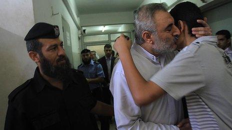Fathi Ashram (centre) hugs his son