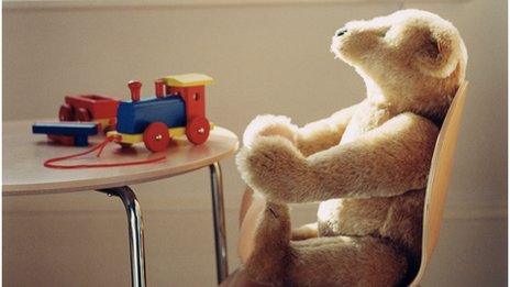 A child's teddy bear and toy train