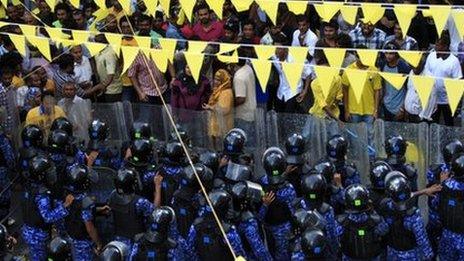 Supporters of former president Mohamed Nasheed face police officers during a protest