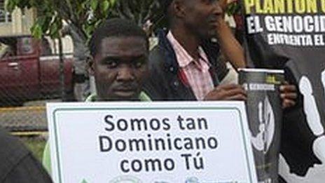 A police officer stands guard as Dominicans of Haitian descent protest outside the Constitutional Court in Santo Domingo, Dominican Republic on 3 October, 2013
