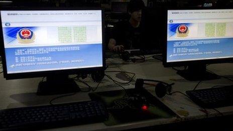 A computer user sits near displays with a message from the Chinese police on the proper use of the internet at an internet cafe in Beijing, China, Monday, 19 August 2013