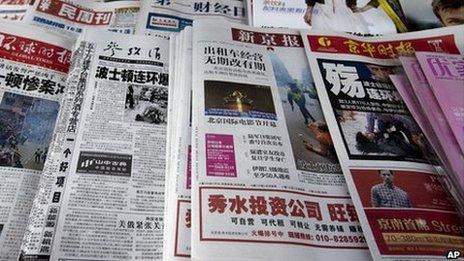 Chinese newspapers with the headlines of Boston Marathon bombings that killed three and wounded more than 170 people, are sold at a newsstand in Beijing, China Wednesday, April 17, 2013.
