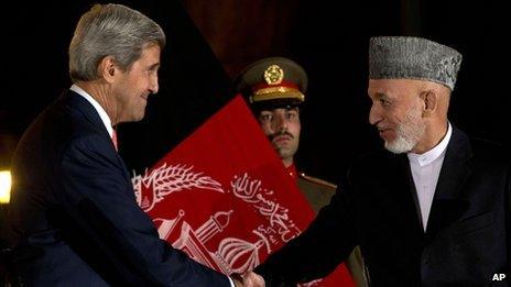 US Secretary of State John Kerry shakes hands with Afghan President Hamid Karzai at a news conference in Kabul, Afghanistan on 12 October 2013