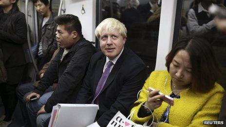 Visiting London Mayor Boris Johnson (C) looks up as he takes a subway in Beijing, 15 October 2013