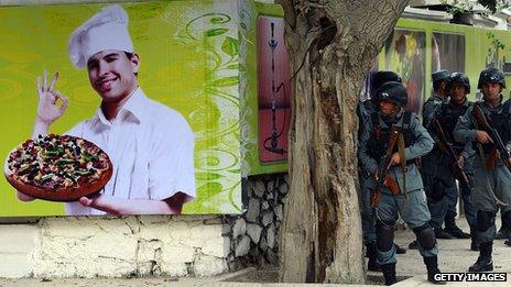 Afghan policemen take position at the site of a clash between Afghan security forces and Taliban fighters in Kabul on May 24, 2013.