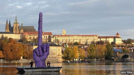 Workers anchor a boat bearing an installation work by Czech visual artist David Cerny in front of the Prague Castle